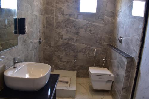 a bathroom with a sink and a toilet at Hotel Kusum Palace in Gaya