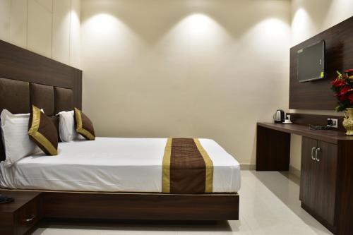 a bedroom with a large bed and a television at Hotel Kusum Palace in Gaya
