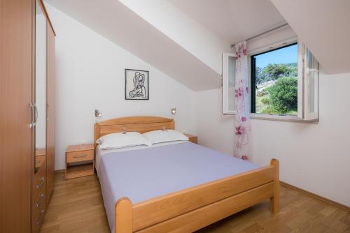 a bedroom with a bed and a window at Apartments Stipe Plazibat in Hvar