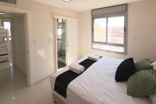um quarto com uma cama grande e uma janela em YalaRent Villa Dolina with private pool em Eilat