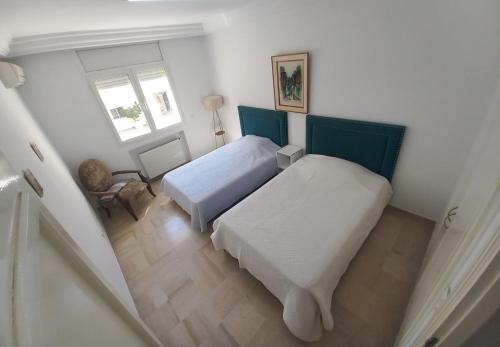 een kleine slaapkamer met 2 bedden en een raam bij Cozy Inn Lac 2 in Tunis