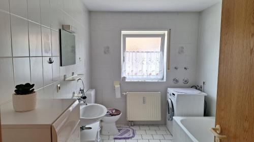 La salle de bains blanche est pourvue d'un lavabo et de toilettes. dans l'établissement Ferienwohnung Schwanau Nähe Europapark, à Schwanau