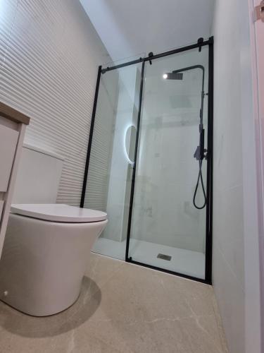 a bathroom with a toilet and a glass shower at Casa Casco Antiguo in Linares