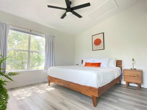 biała sypialnia z łóżkiem i wentylatorem sufitowym w obiekcie Sanctuary Gainesville Bright 2 BR King Condo w mieście Gainesville
