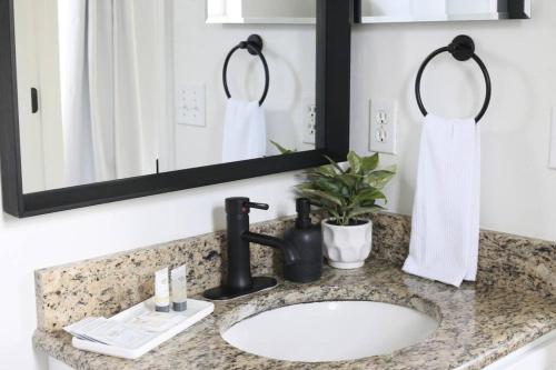W łazience znajduje się umywalka i lustro. w obiekcie Sanctuary Gainesville Bright 2 BR King Condo w mieście Gainesville