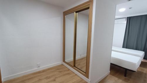 a dressing room with a mirror and a bed at Hostal Zaragoza Centro in Zaragoza