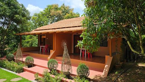 a house with a deck in a garden at Nature First Eco-Village in Dhārwād