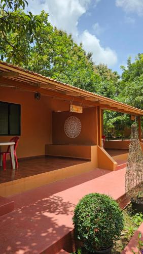 a porch of a house with a table and a bench at Nature First Eco-Village in Dhārwād