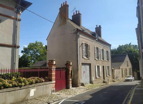 a house with a red gate on a street at Ô Bulles de Loire, Châteauneuf-sur-Loire in Châteauneuf-sur-Loire