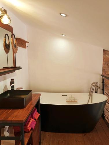 La salle de bains est pourvue d'une baignoire et d'un lavabo. dans l'établissement La Bucolique, Chambres et Jardin d'Hôtes, à Sabran