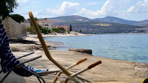 a chair with baseball bats sitting on a beach at Apartmani Krolo Trogir otok Čiovo in Trogir