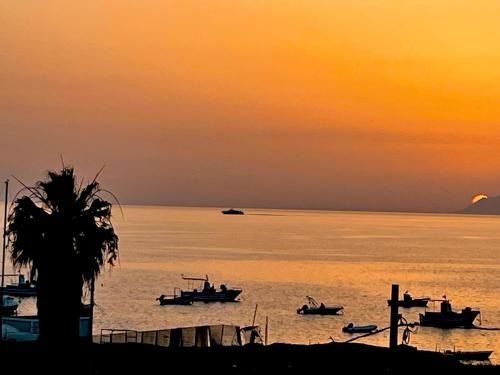 a group of boats in the water at sunset at Residence Sunset Egadi in Marsala