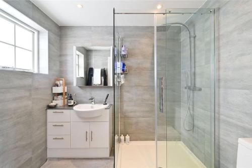 a bathroom with a glass shower and a sink at Large 3 Bedroom Covent Garden Apartment in London