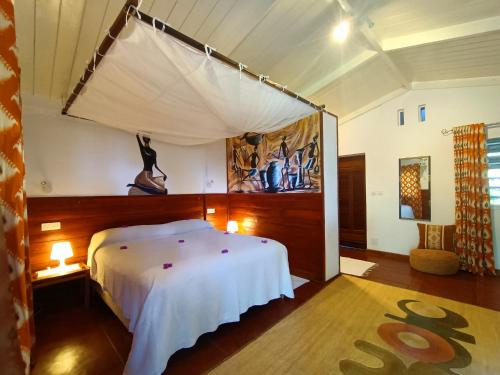 a bedroom with a white bed in a room at MADIROKELY HOUSE Nosy Be in Ambatoloaka