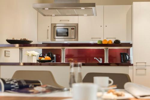 a kitchen with a table and a microwave at Living Apartments Ludwigshafen in Ludwigshafen am Rhein