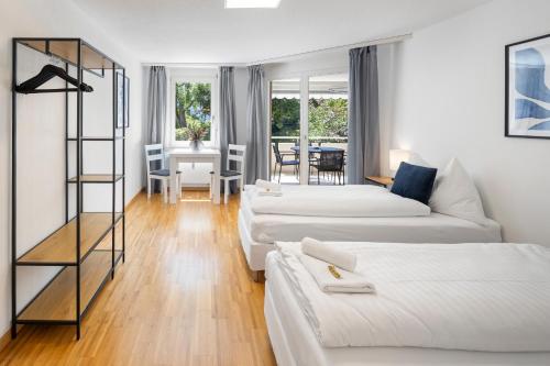 a white living room with two beds and a table at habu bei Plättli Zoo cosy stay in Frauenfeld