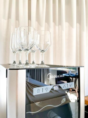 four wine glasses sitting on top of a table at La Plage Residence in Garopaba
