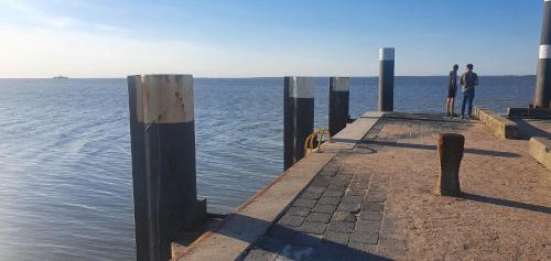 two people standing on a pier over the water at De Groote Medwert in Holwerd