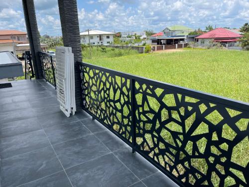 a black fence on a balcony with a yard at Boa vista appartementen in Paramaribo