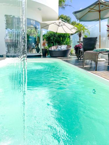 a swimming pool with a water fountain at La Plage Residence in Garopaba
