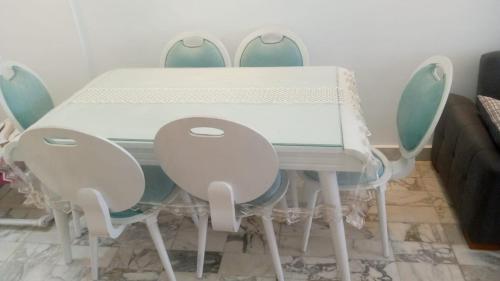 a dining room table with four chairs around it at شقة فاخرة علي البحر مباشرة لوران الاسكندرية in Alexandria