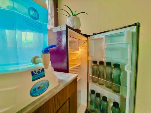 an open refrigerator filled with lots of soda bottles at UVs Homestay in Haridwār