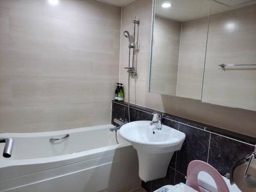 a bathroom with a sink and a toilet and a bath tub at Ocean & sunrise View-10 seconds of beach walk - Three bedrooms in Goseong