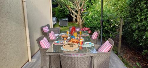 - une table extérieure avec des chaises et une table avec de la nourriture dans l'établissement Les chambres de Fontenon, à Saint-Avé