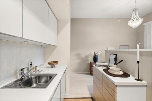 a kitchen with white cabinets and a sink at Unique Oslo/Vika Apartment in Oslo