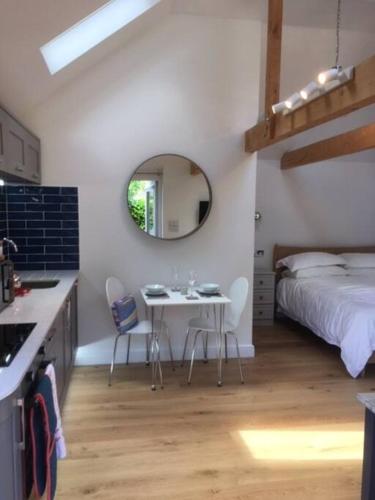 a bedroom with a bed and a table and chairs at Cliff Lane Annexe: stylish in a perfect location. in Cromer