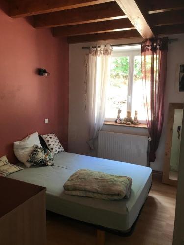 une chambre avec un grand lit avec une fenêtre dans l'établissement Maison de campagne calme et sérénité, à Chazelles-sur-Lavieu