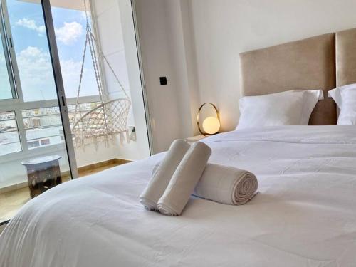 - une chambre avec un lit blanc et des serviettes dans l'établissement Appartement au cœur de Rabat, à Rabat