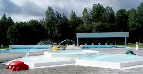 a large swimming pool with a water fountain in a park at Gulliga torpet in Vislanda