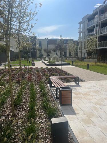 a park with a bench and trees and a building at Apartament Moja Klonova in Kielce