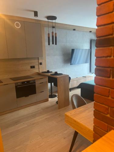 uma cozinha e sala de jantar com uma mesa e um sofá em Apartament Moja Klonova em Kielce