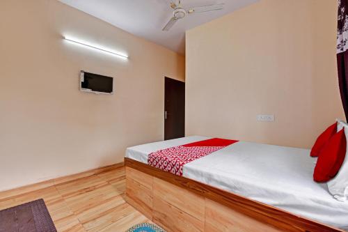 a bedroom with a bed and a flat screen tv at Super OYO Flagship 81472 The Harsa Inn in Sānkchi
