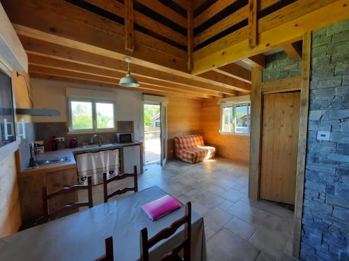 cocina y sala de estar con mesa y sillas en Gîte Les sepneilles !, en Gérardmer