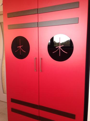 a red cabinet with two round windows on it at Zapovedni Rai in Primorsko