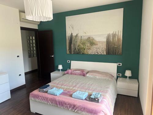 a bedroom with a bed with a painting on the wall at PennysHouse in San Giovanni Teatino