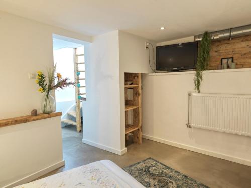 ein Wohnzimmer mit einem TV an der Wand in der Unterkunft Tiny Beachhouse in Scheveningen