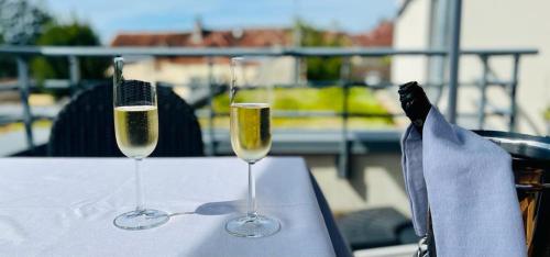 due bicchieri di champagne seduti su un tavolo di Au Coeur Des Bulles a Loches-sur-Ource