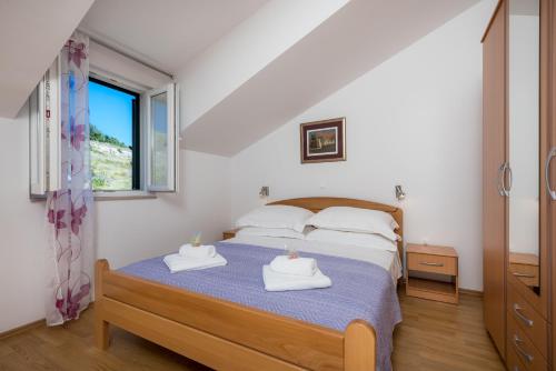 a bedroom with a bed with two towels on it at Apartments Plazibat in Hvar