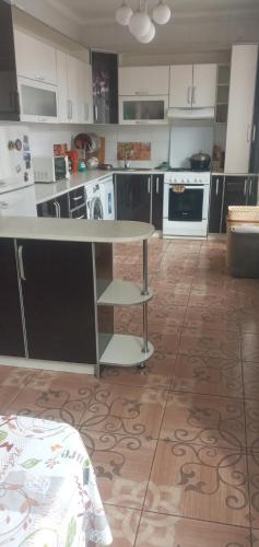a kitchen with a table in the middle of it at Уютная вилла в центре Бишкека in Bishkek