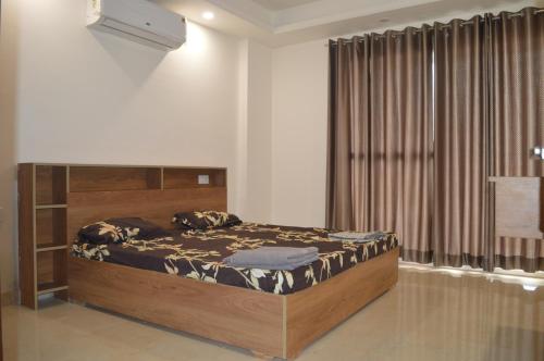a bedroom with a bed and a large window at Aarya Rishikesh - Luxurious 2 BHK in Rishīkesh