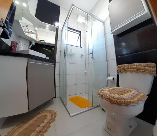 a bathroom with a toilet and a glass shower at Santa House no Centro in Santa Cruz do Sul