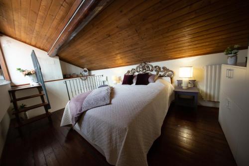 a bedroom with a large bed with a wooden ceiling at Appartamento "Bella vista" sul Lago di Como in Faggeto Lario 