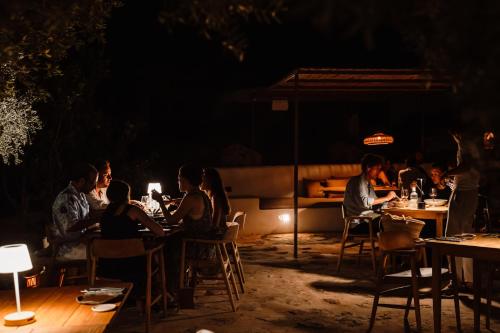 a group of people sitting at tables at night at Aguamadera in Santa Eularia des Riu