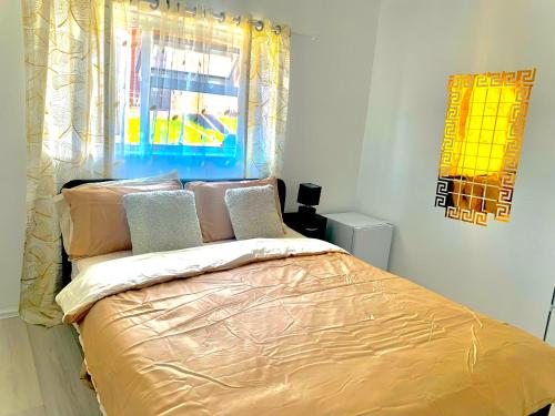 a bedroom with a bed with gold sheets and a window at Double room bentilee in Bucknall