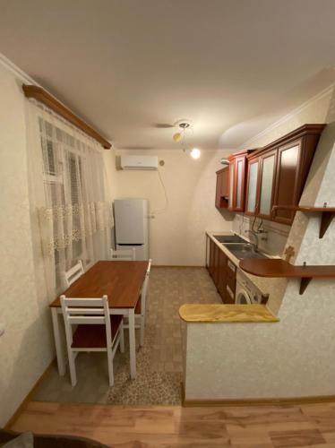a kitchen with a wooden table and a kitchen with a refrigerator at Studio apartment in Yeghegnadzor