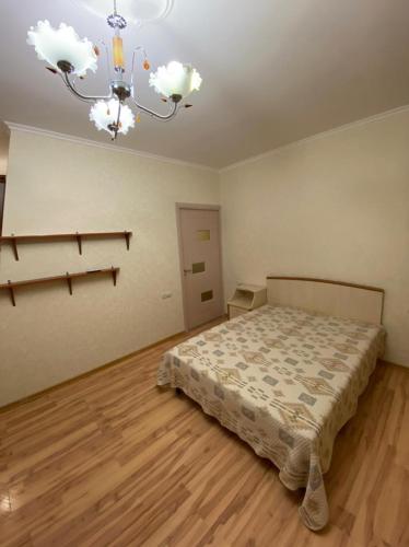 a bedroom with a bed and a chandelier at Studio apartment in Yeghegnadzor